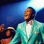 Home 3 바베이도스 출신 유명 음악가 - **Jackie Opel: The Spouge Pioneer on Stage**
A vibrant, dynamic full-body portrait of Jackie Ope...